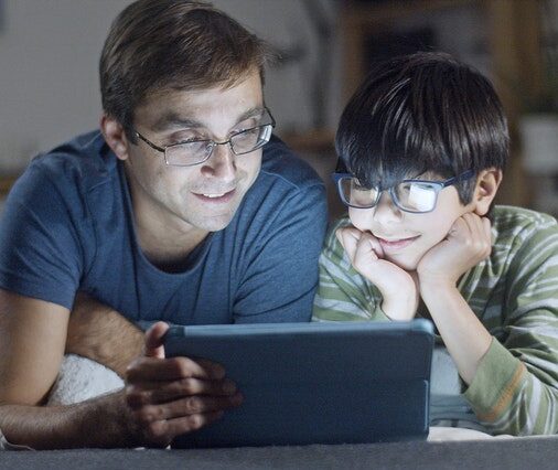 Dad and son looking at tablet together and smiling